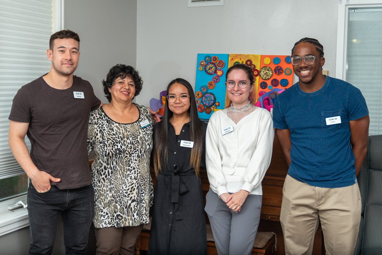 a group of people standing next to each other and smiling